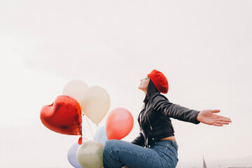 Wall Mural - woman holding colorful balloons against the sky