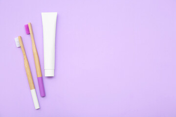 Wall Mural - Toothbrushes with toothpaste on lilac background