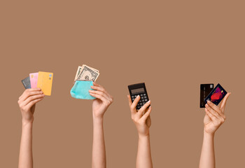 Wall Mural - Female hands with credit cards, wallet and calculator on brown background