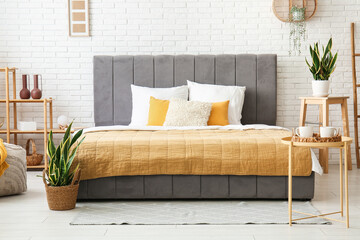 Canvas Print - Stylish bed, houseplants, coffee table and shelving unit in beautiful bedroom