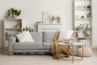 © Pixel-Shot - Interior of cozy living room with grey sofa and reed diffuser on coffee table