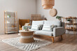 © Pixel-Shot - Interior of living room with sofa, rattan table and shelf units