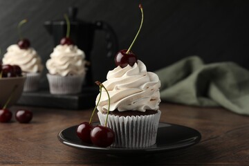 Wall Mural - Delicious cupcakes with cream and cherries on wooden table, closeup