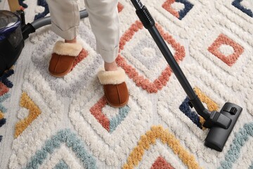 Wall Mural - Woman cleaning carpet with vacuum, top view