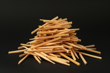 Aufkleber - A collection of wooden toothpicks arranged on a black surface, great for use in designs needing a unique texture or pattern