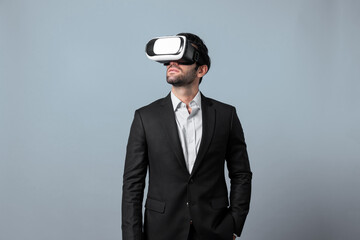 Skilled project manager with VR glasses standing and looking around. Caucasian businessman connecting with metaverse and virtual reality world while wearing suit. Innovation technology. Deviation.