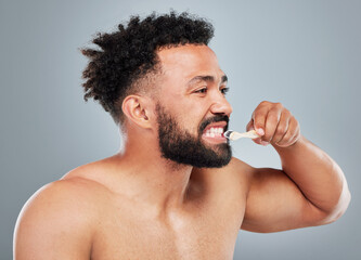 Canvas Print - Dental care, man or brushing teeth in studio for hygiene, whitening or clean with bamboo toothbrush. Male person, organic product or wooden tool on gray background for fresh breath, routine or health