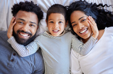 Poster - Above family, boy and happy portrait on bed for morning peace, bonding time and relationship trust in home. Parents, young child and smile together on mattress for wake up, relax and love support