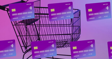 Wall Mural - Image of credit cards over shopping cart on purple background