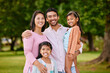 © Delcio Fernandes/peopleimages.com - Portrait, happy and family with love outdoor for bonding, care and embrace of travel adventure at park. Smile, Asian people and parents with kids for support and fun holiday together for childhood