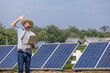 © kamonrat - A Forward-Thinking Farmer Using a Laptop to Monitor Solar Panels in a Field, Highlighting the Integration of Renewable Energy and Technology in Modern Agriculture