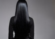 © Jati - A woman with long black hair is standing in front of a gray background