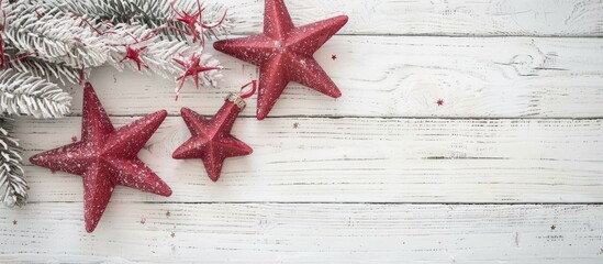 Aufkleber - On a white wooden surface, a festive display features a light pink garland with two red stars, creating a Christmas-themed copy space image with a soft focus.