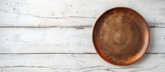 Poster - Empty brown plate on white wooden table with ample copy space image.