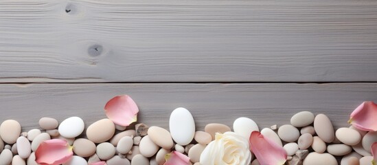 Poster - Spa-themed background with sea pebbles and rose petals on a neutral mat with copy space image.