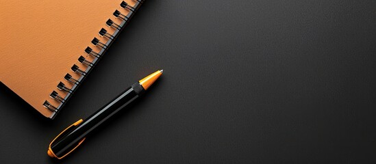 Canvas Print - Top view of a notebook and pen on a black background with ample copy space image.