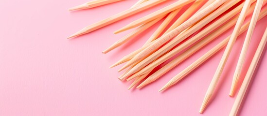 Poster - Toothpicks made of wood placed on a pink backdrop with copy space image.