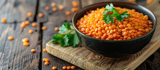 Aufkleber - A bowl of tasty red lentils garnished with parsley, set on a wooden table, captured in a close-up copy space image.