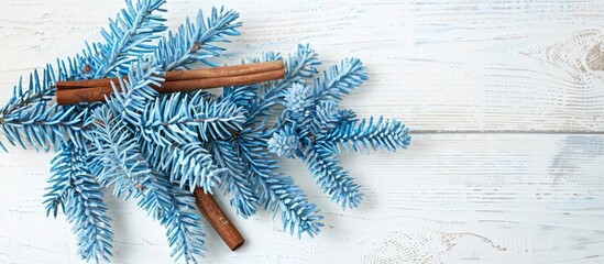 Poster - A festive setting with a blue fir tree branch, wooden cut, cinnamon sticks on a white wooden backdrop for a Christmas card, with space for custom text or images.