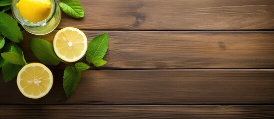 Canvas Print - Wooden background hosts a glass of refreshing lemonade with mint leaves and lemons, creating a visually appealing copy space image.