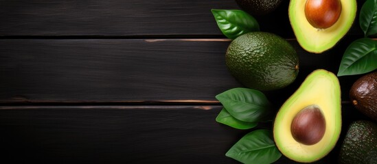 Poster - Flat lay arrangement of whole and halved avocados on a dark wooden surface, featuring ample copy space image.