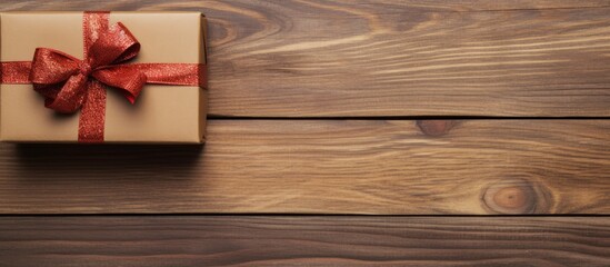 Poster - Top view of a stylishly decorated Christmas gift with a ribbon on a wooden background, perfect for a copy space image.