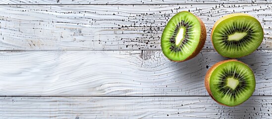 Poster - Two kiwifruit halves displayed on a white wooden background with space for additional content in the image.