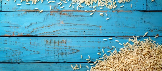 Poster - Top-down perspective of dried paddy rice on a blue wooden surface, offering room for text or design in a copy space image.