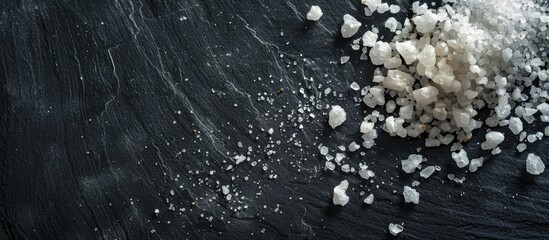 Poster - Sea salt grains sprinkled on a dark surface with ample copy space image.
