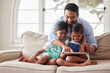 © Alexis S/peopleimages.com - Father, girl and children with tablet on sofa with click on app, laugh and happy for show in family home. Man, dad and daughter kids with streaming, subscription and relax with movies in Indonesia