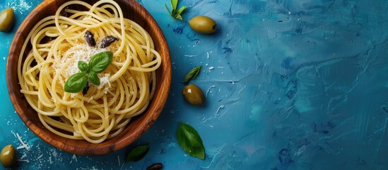 Aufkleber - An Italian plate of anchovy spaghetti with salt in a wooden bowl and olives on a blue texture background Top view with copy space image