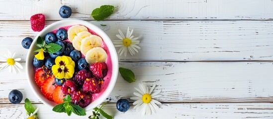 Aufkleber - Top down view of a delectable smoothie bowl adorned with fresh fruits blueberries and flowers Placed on a white wooden surface offering ample copy space image
