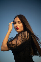 Portrait of a young and beautiful long hair woman at sunset