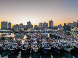 Bangeojin, Dong-gu, Ulsan, South Korea - January 11, 2024: High angle view of fishing boats moored on the sea in a row connected each other at Bangeojin Port
