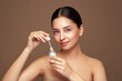 © Oleg Gekman - Beautiful elegant woman holding a cosmetic jar of oil serum or hyaluronic acid in her hand. Perfect facial skin