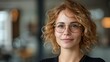 © PaulShlykov - Cute German Project Manager Young Woman in her 40s with Very Short Curly Hair and Brown Eyes, Glasses, as a Professional Business Person at her Working Space