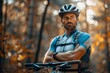 © Jane_S - Cyclist with crossed arms and a helmet, standing beside a bike in a natural outdoor setting.