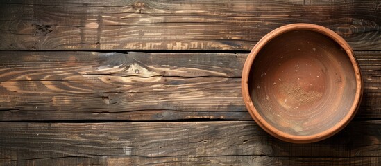 Poster - Wooden background with an empty clay bowl ideal for adding text or images copy space image
