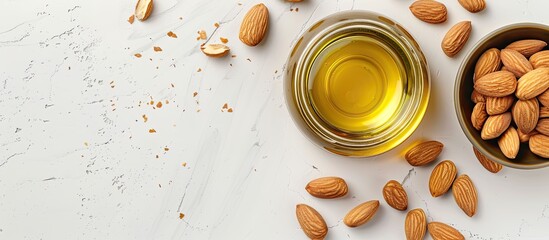 Poster - A jar of almond oil placed near a bowl of almonds on a white background viewed from the top creating an appealing copy space image for cosmetic purposes