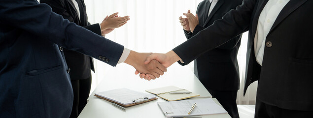 Wall Mural - Two business executive shake hand in boardroom, sealing agreement merging two company. Handshake symbolize business partnership and cooperation. Corporate acquisition and merger concept. Shrewd