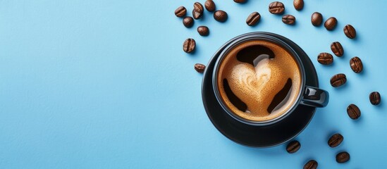 Wall Mural - Top down view of heart shaped black espresso coffee cup with scattered grains on blue surface offering ample copy space image