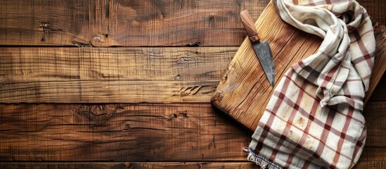 Poster - Top view of a cutting board on a wooden kitchen table with a towel underneath creating a rustic kitchen scene with copy space image
