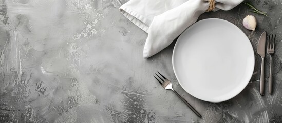 Poster - Minimalistic gray concept with a ceramic white plate cutlery and a napkin on a gray background ideal for text or image placement. copy space available