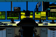 © yaqui_villegas - A professional trader intensely monitoring several computer screens with green-lit data displays in a modern office building during nighttime, symbolizing financial diligence.