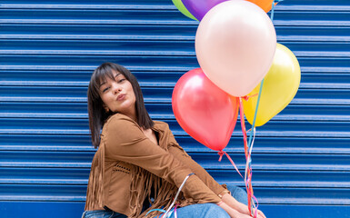 Wall Mural - cheerful woman holding colorful flying balloons