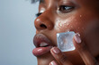 © AnaBeln - closeup of a black woman doing ice cube beauty treatment to her face. Space for copy