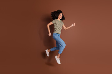 Sticker - Full length photo of adorable lovely girl wear khaki t-shirt jumping high running empty space isolated brown color background