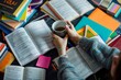 © Elmira - A student sits at a desk surrounded by open textbooks, colorful stationery, and a cup of tea, taking a break from studying