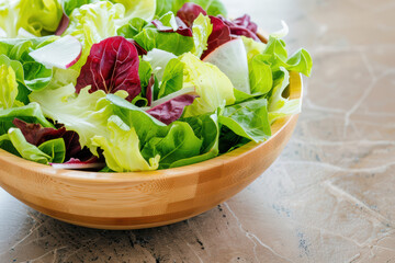 Wall Mural - A colorful fresh salad with mixed greens and lettuce leaves in a wooden bowl on a marble surface, perfect for healthy eating and meal inspiration.