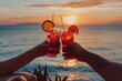 © Milos - A couple holds up two glasses with drinks as they toast by the ocean, with a breathtaking sunset in the background, celebrating a special moment in a picturesque setting.